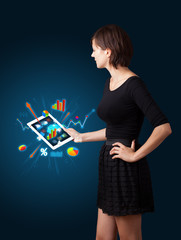 woman holding modern tablet with colorful diagrams and graphs