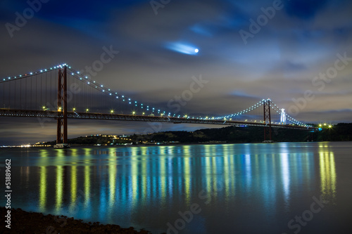 Fotoboard na płycie 25 de abril most nad Tagus rzeką w Lisbon przy nocą
