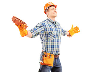 Canvas Print - Happy manual worker holding a brick and spreading arms