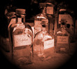 Old medicine bottles with labels and corks in sepia tone