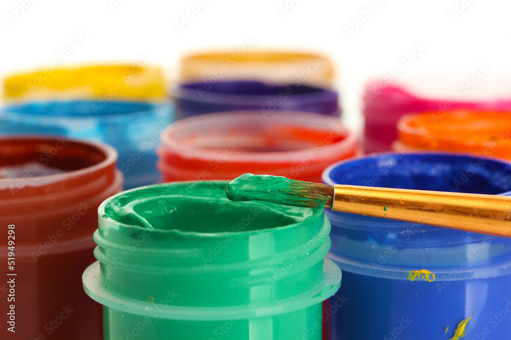 jars with multicolored gouache on white background close-up
