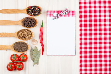  Red and white tablecloth, tomatoes, spices in spoons on wood