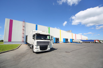 Trucks stand near warehouse of factory