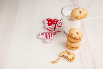 Biscuits on a plate with milk and hearts, breakfast on white bac