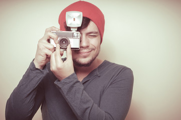 young stylish man holding old camera