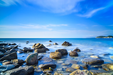 Baratti bay, rocks in a blue ocean on sunset. Tuscany, Italy.