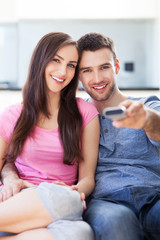 Canvas Print - Young couple with TV remote