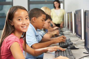 Elementary Students Working At Computers In Classroom