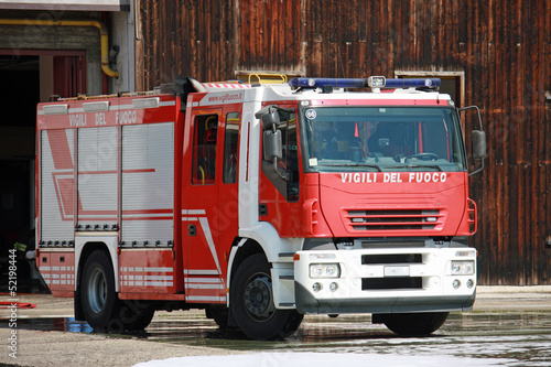 Fototapeta na wymiar fire truck after shutting the burning of a house in the city