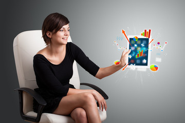 woman holding modern tablet with colorful diagrams and graphs