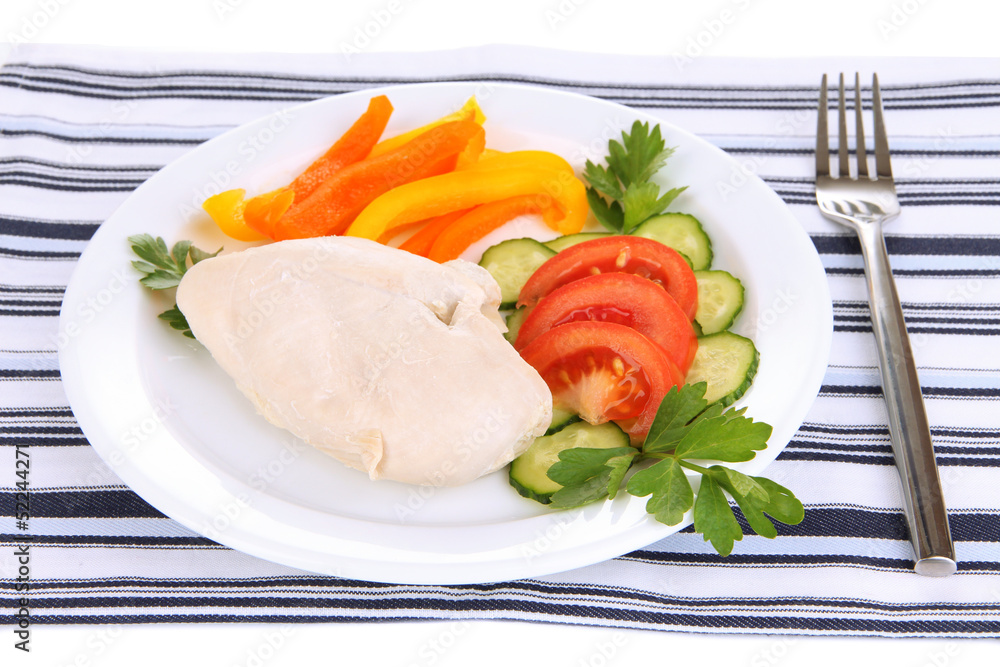 Boiled chicken breast on plate with vegetables close up