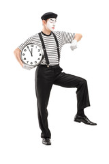 Wall Mural - Full length portrait of a mime artist holding a clock and checki