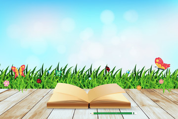 Fresh spring green grass with blue sky bokeh and open book and w