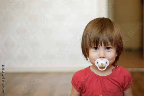 Fotografija  girl with a soother in her mouth