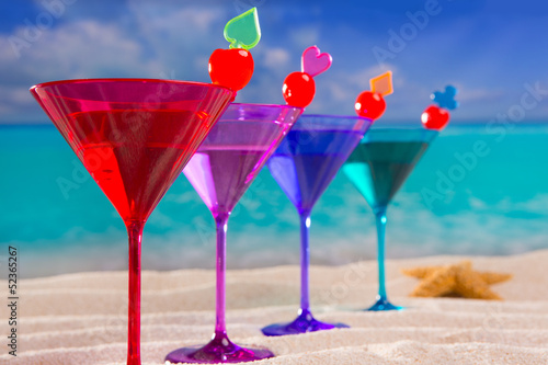 Fototapeta na wymiar colorful cocktail in a row with cherry on tropical sand beach