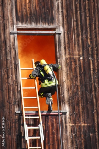 Fotoboard na płycie Dzielni strażacy z butlą tlenową wchodzą do domu