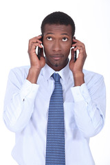 Businessman holding two telephones