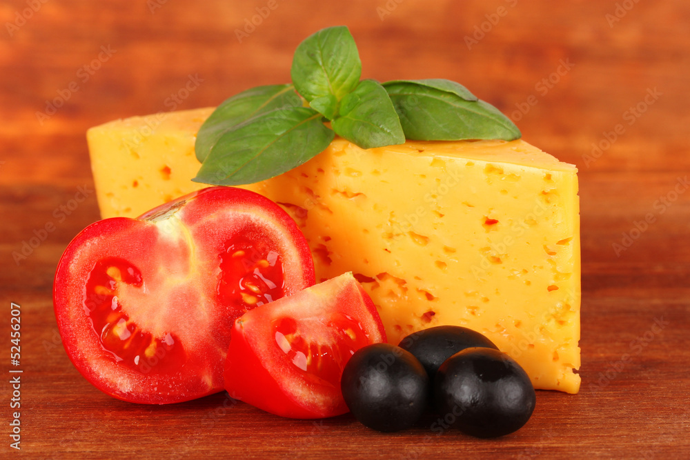 Cheese,basil and vegetables on wooden background