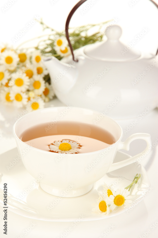 Cup of herbal tea with camomiles close up