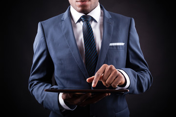 Businessman working on a digital tablet against black backgroun