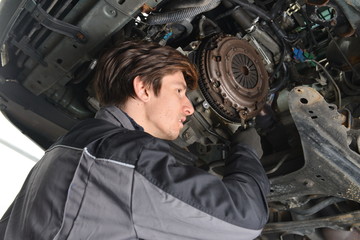 Auto Mechanic is working in car repair shop.