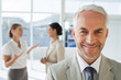 © WavebreakmediaMicro - Smiling businessman standing in front of colleagues