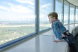 Little girl looking through the window at skyscraper