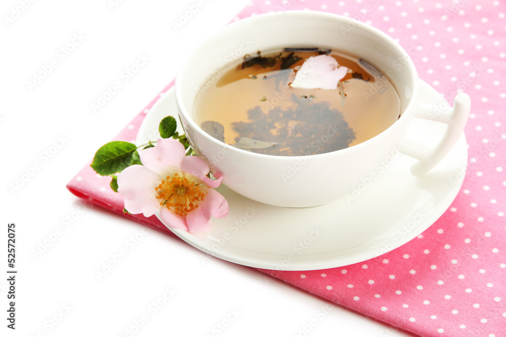 Cup of herbal tea with hip rose flowers, isolated on white