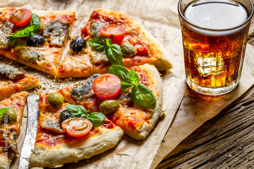 Fototapeta na szkło Świeżo upieczona pizza podawana z zimnym napojem