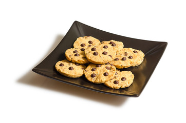 Wall Mural - Chocolate chip cookies on a black plate isolated on white backgr