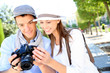 Cheerful couple with photo camera in touristic area
