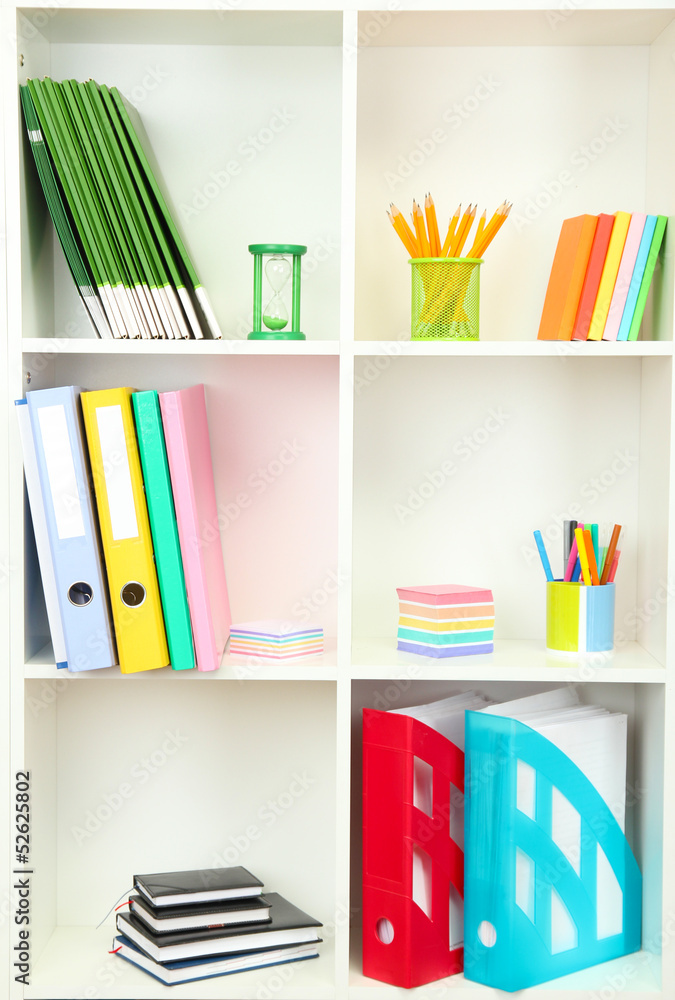 White office shelves with different stationery, close up