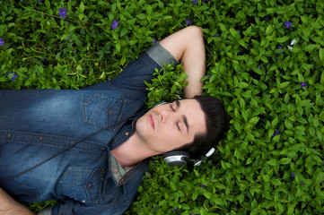 Young man resting listening to music on headphones