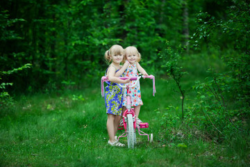 Girls ride bicycle in park