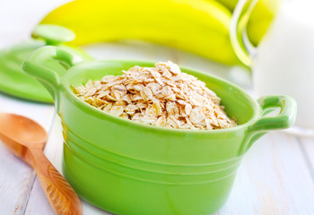 Poster - oat flakes in the green bowl with banana and milk