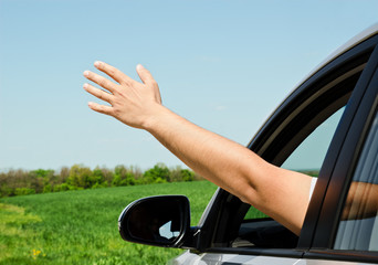 Man inside car showing his hand