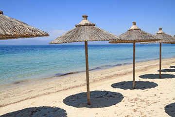 Wall Mural - Straw umbrellas by the sea