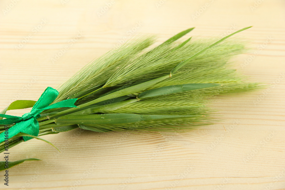 Green spikelets, on wooden background