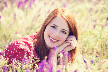 Wall Mural - Redhead girl at green grass at village outdoor