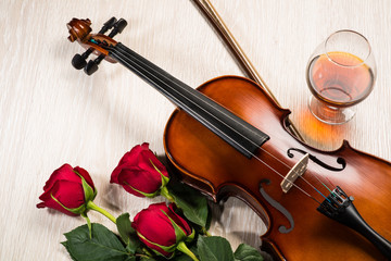 Violin, rose, glass of champagne and music books