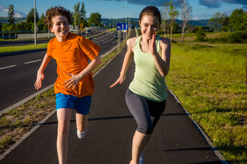 Wall Mural - Girl and boy running, jumping outdoor