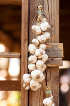 Garlics Hanging In Old Wooden Market