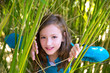 girl playing in nature  peeping from green canes