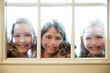 three sister friends looking through the rainy window