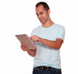© pablocalvog - Latin adult man using his tablet pc