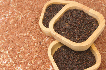 Thai black jasmine rice (Rice berry) in wooden bowl on brown ric