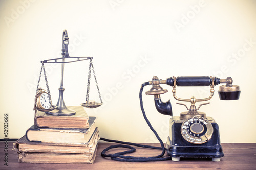 Fototapeta na wymiar Vintage old telephone, scales with watches and money, books