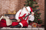 Fototapeta  - Santa Claus plays the guitar