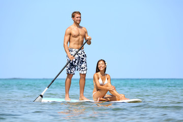 Wall Mural - Beach fun couple on stand up paddleboard