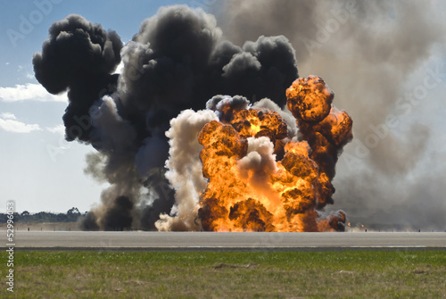 Fotografie, Obraz Fiery explosion with thick black smoke on an airport runway.